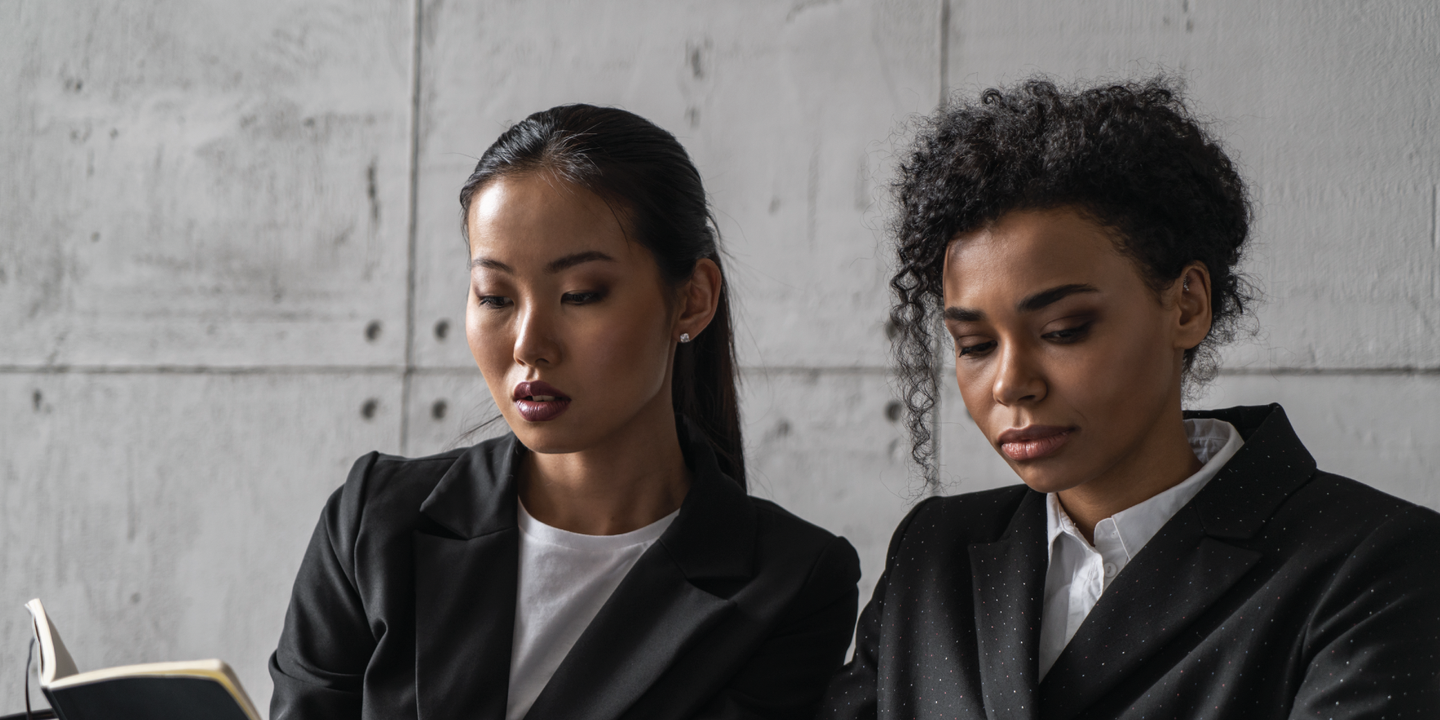 Image of two feminine-presenting individuals talking to each other