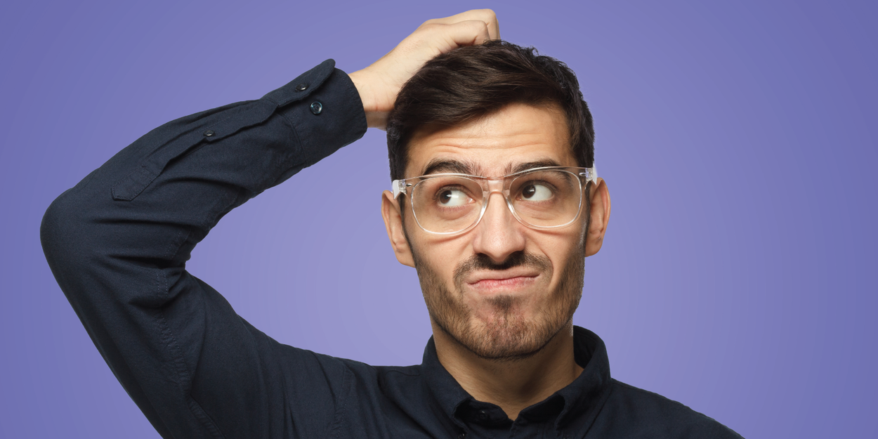 Thoughtful male employee on a purple background