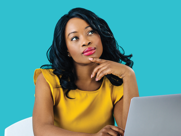 Woman in yellow dress on a computer thinking about employee survey response rates