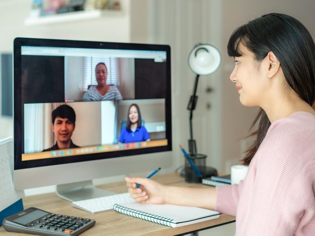 Asian business woman talking to her colleagues about plan in video conference multiethnic business team using computer for a online meeting in video call group of people smart working from home