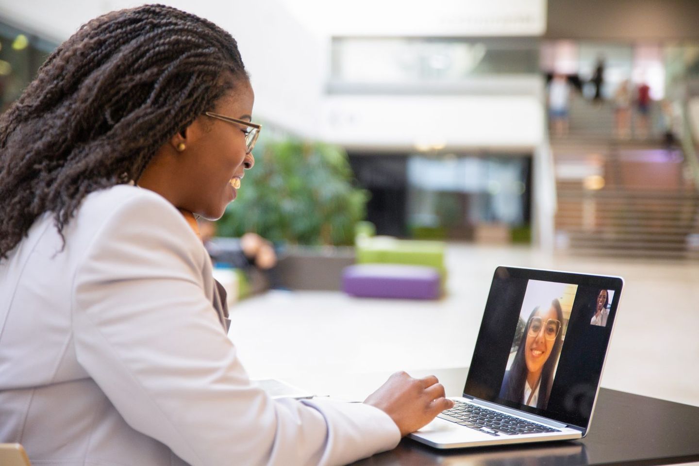 Happy female office friends talking through video call
