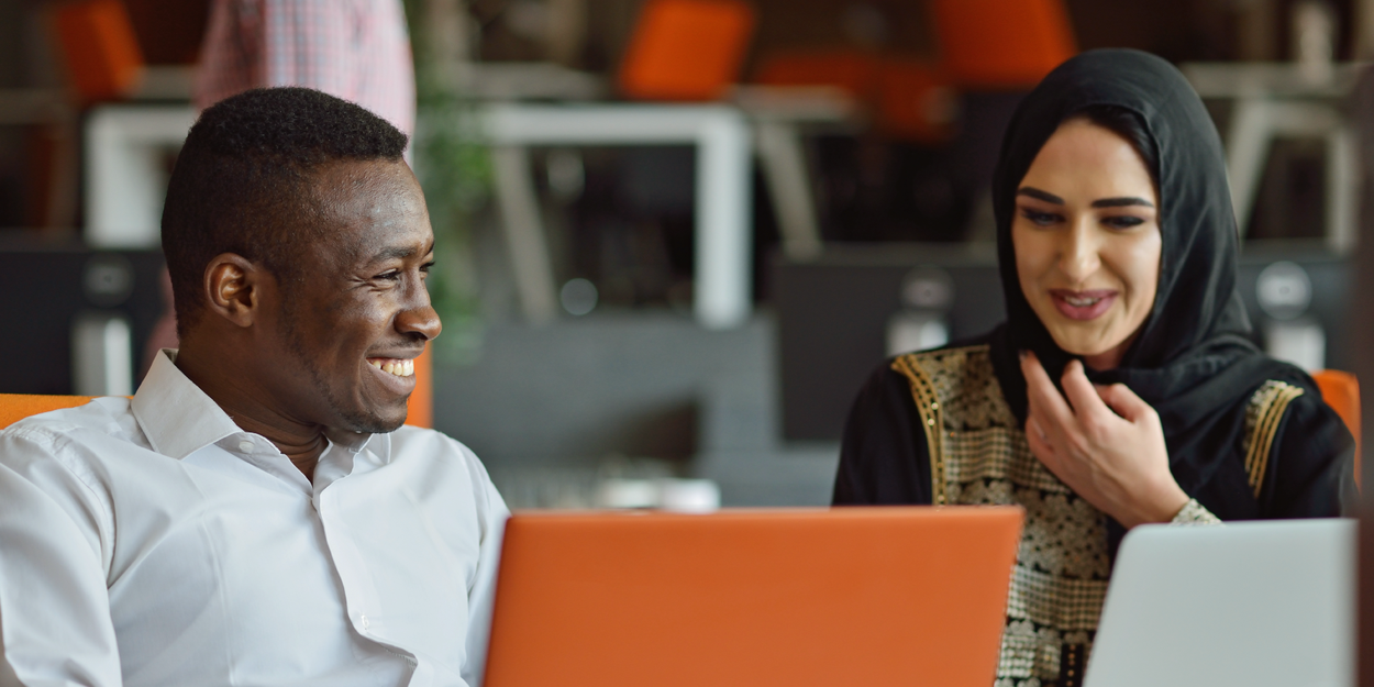 Two people talking with laptops