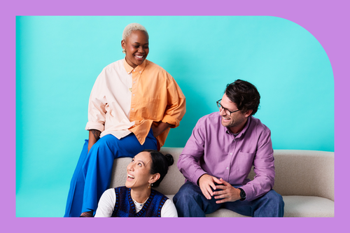 three employees sitting and laughing together