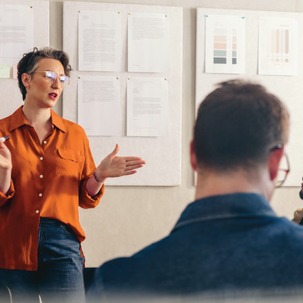 Woman talking to a group of people at a meeting