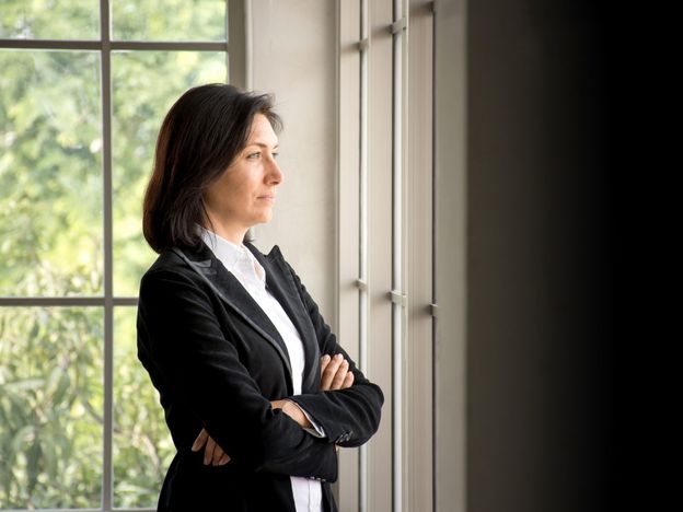 Portrait of confidence caucasian businesswoman crossed her arms and looking out the window