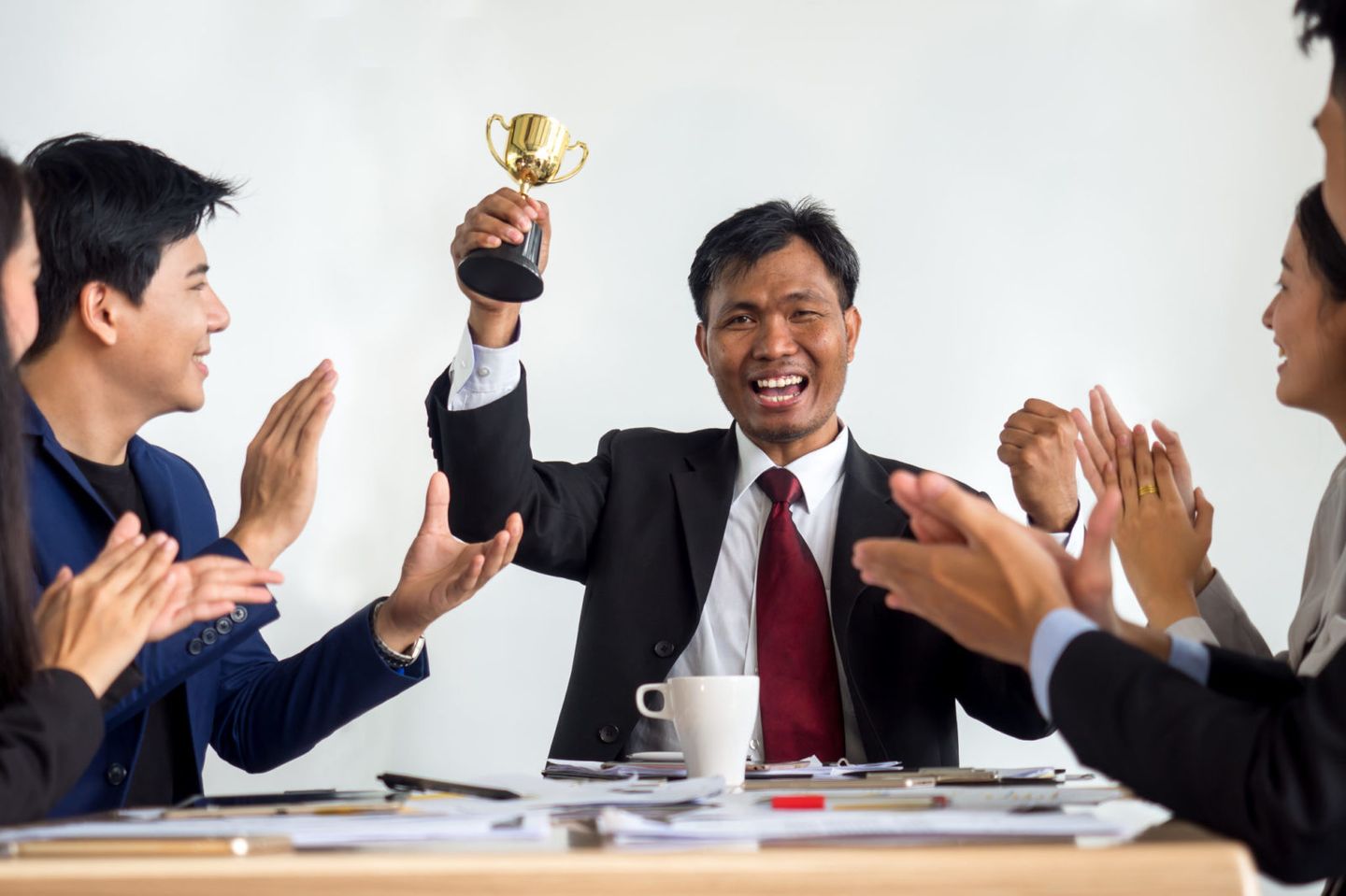Businessman clapping hands with trophy reward winner champion and successful for business