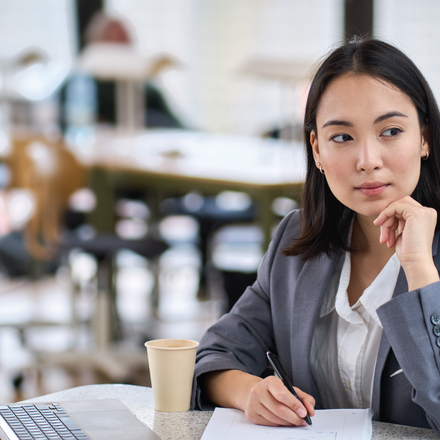 Thoughtful employee looking away from laptop