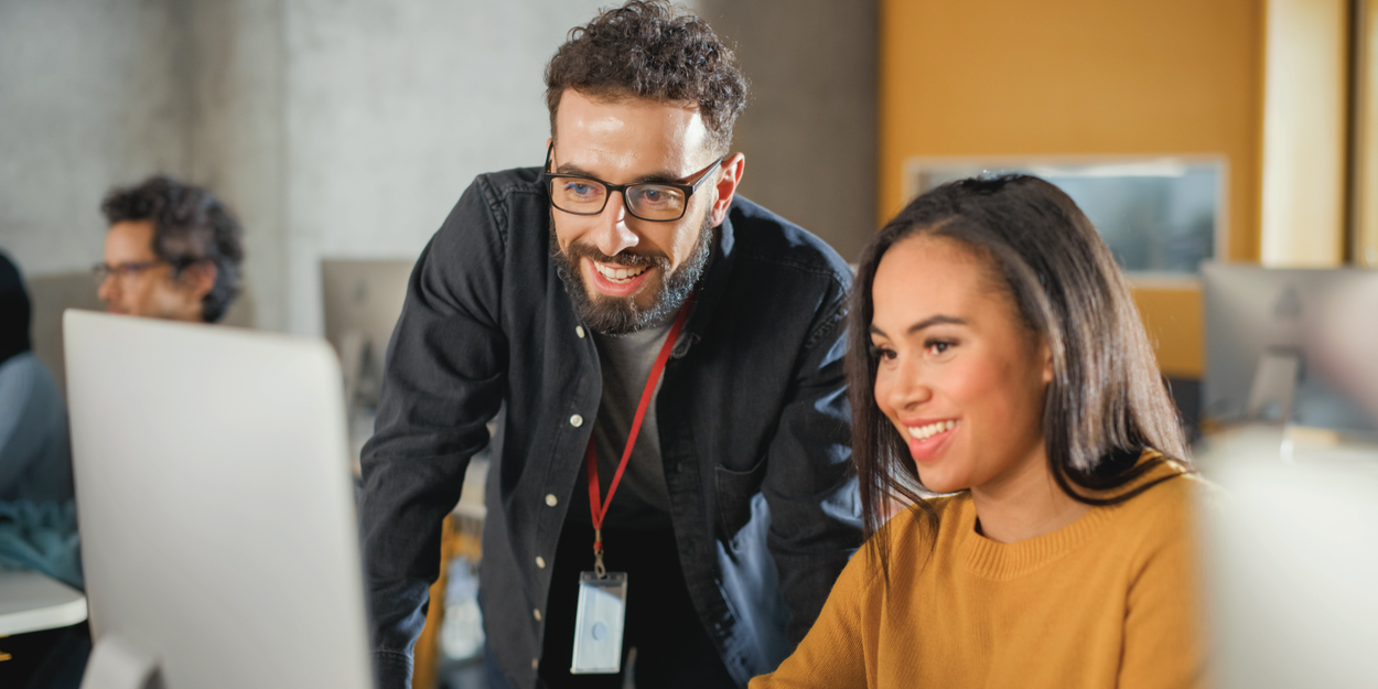 Two employees looking at a laptop