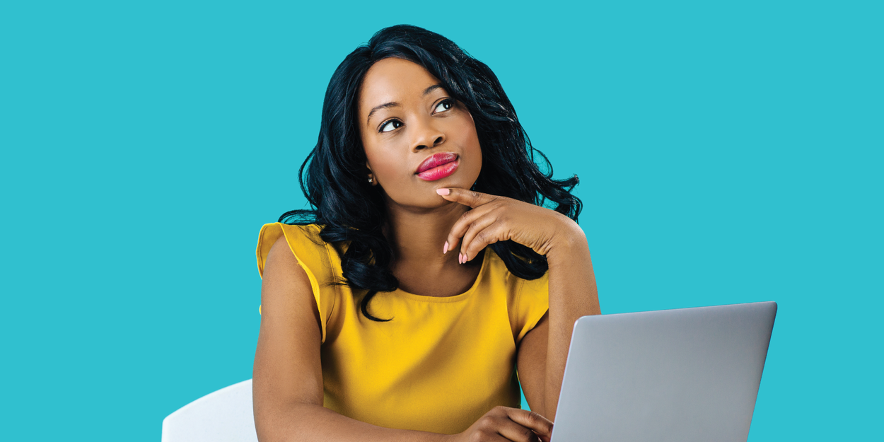 Woman in yellow dress on a computer thinking about employee survey response rates