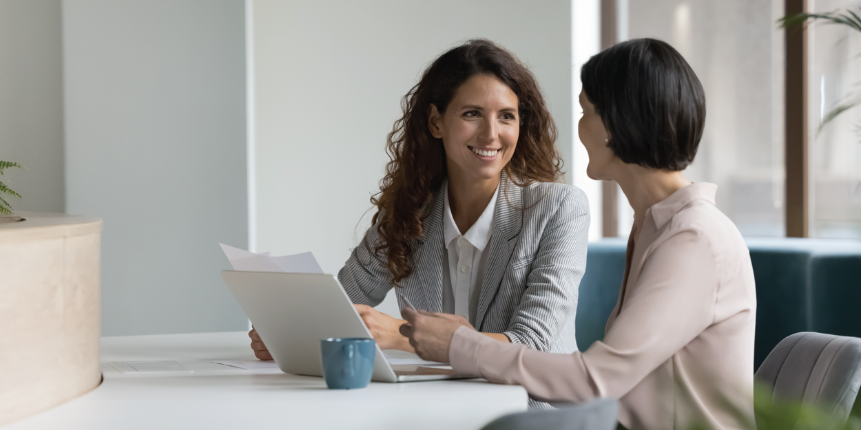 A manager and direct report talking together in the office