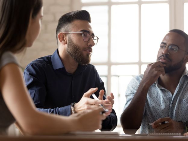 Multiethnic colleagues talk discussing business ideas at meeting