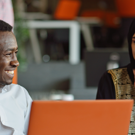 Two people talking with laptops