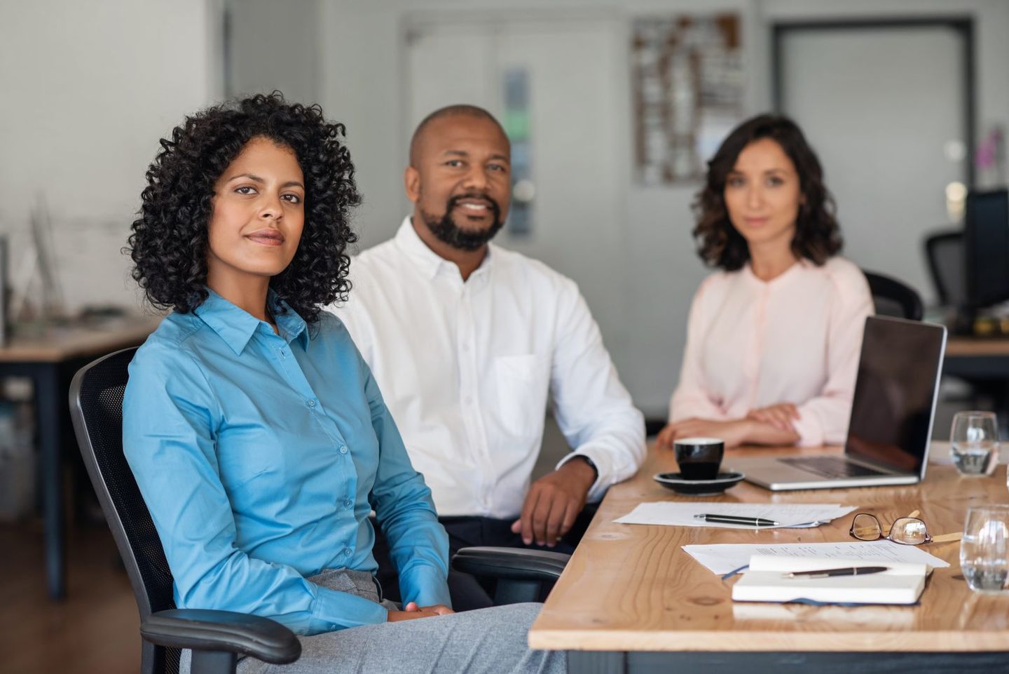 Employees sitting at board room table