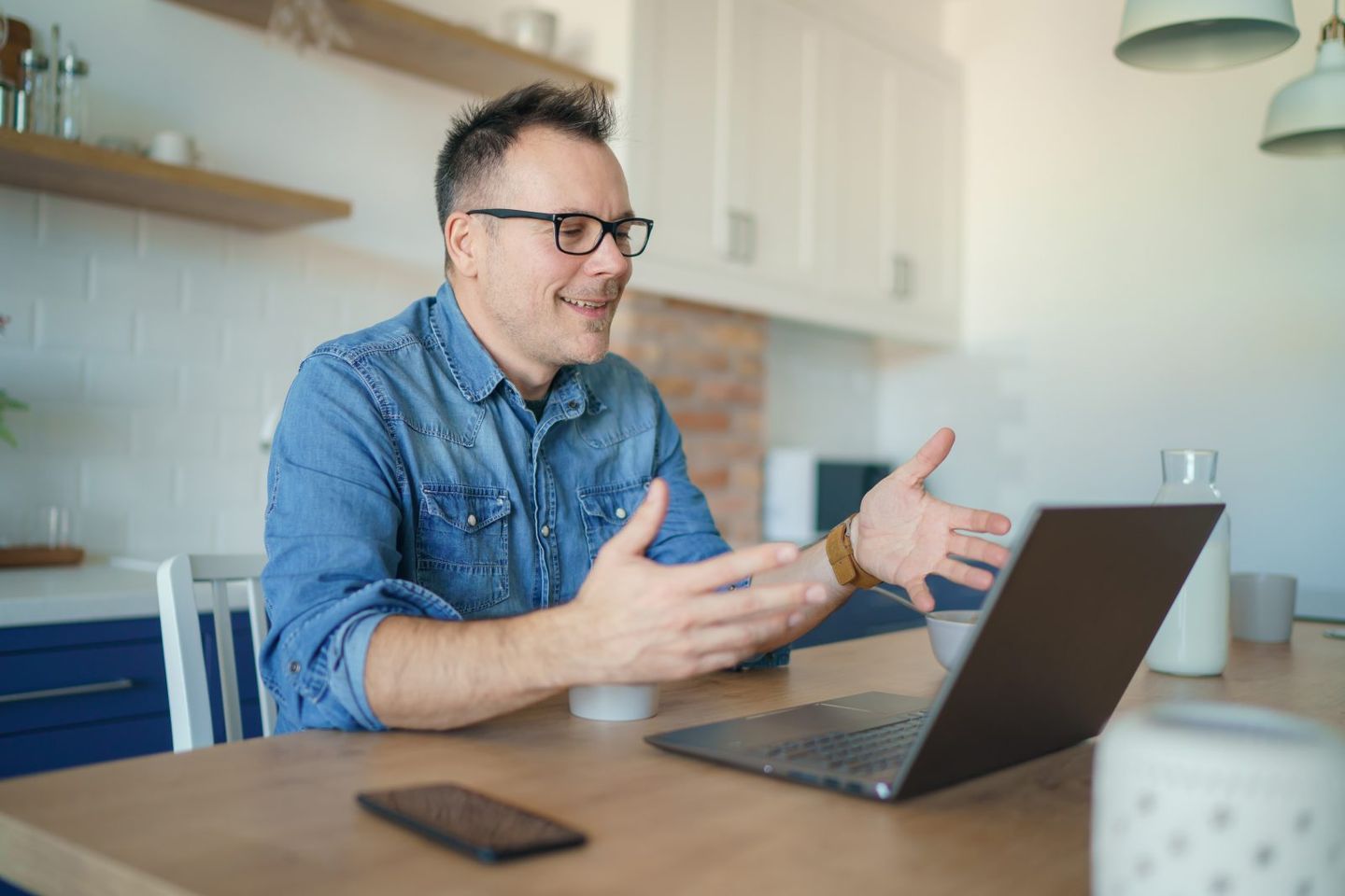 Happy adult man having a video call with a laptop at home