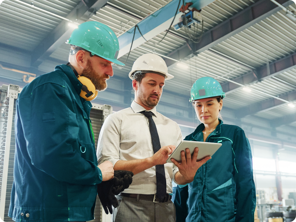 employees on warehouse floor in protective gear with mobile phone