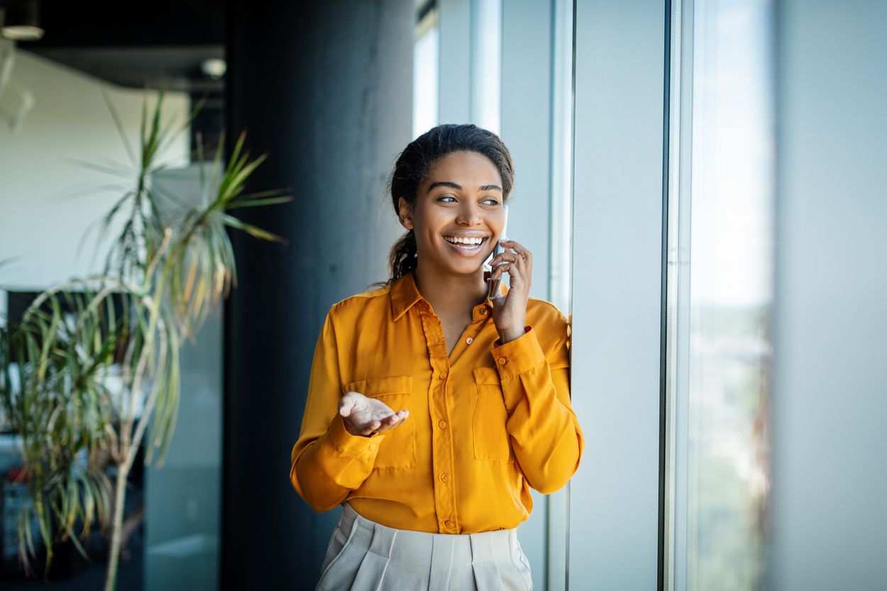 Woman in yellow shirt talking on a phone