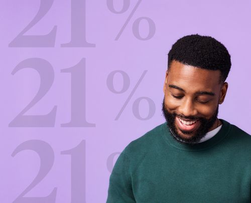 man looking down and smiling in front of purple background