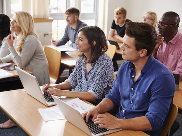 Mature students sitting at desks in adult education class