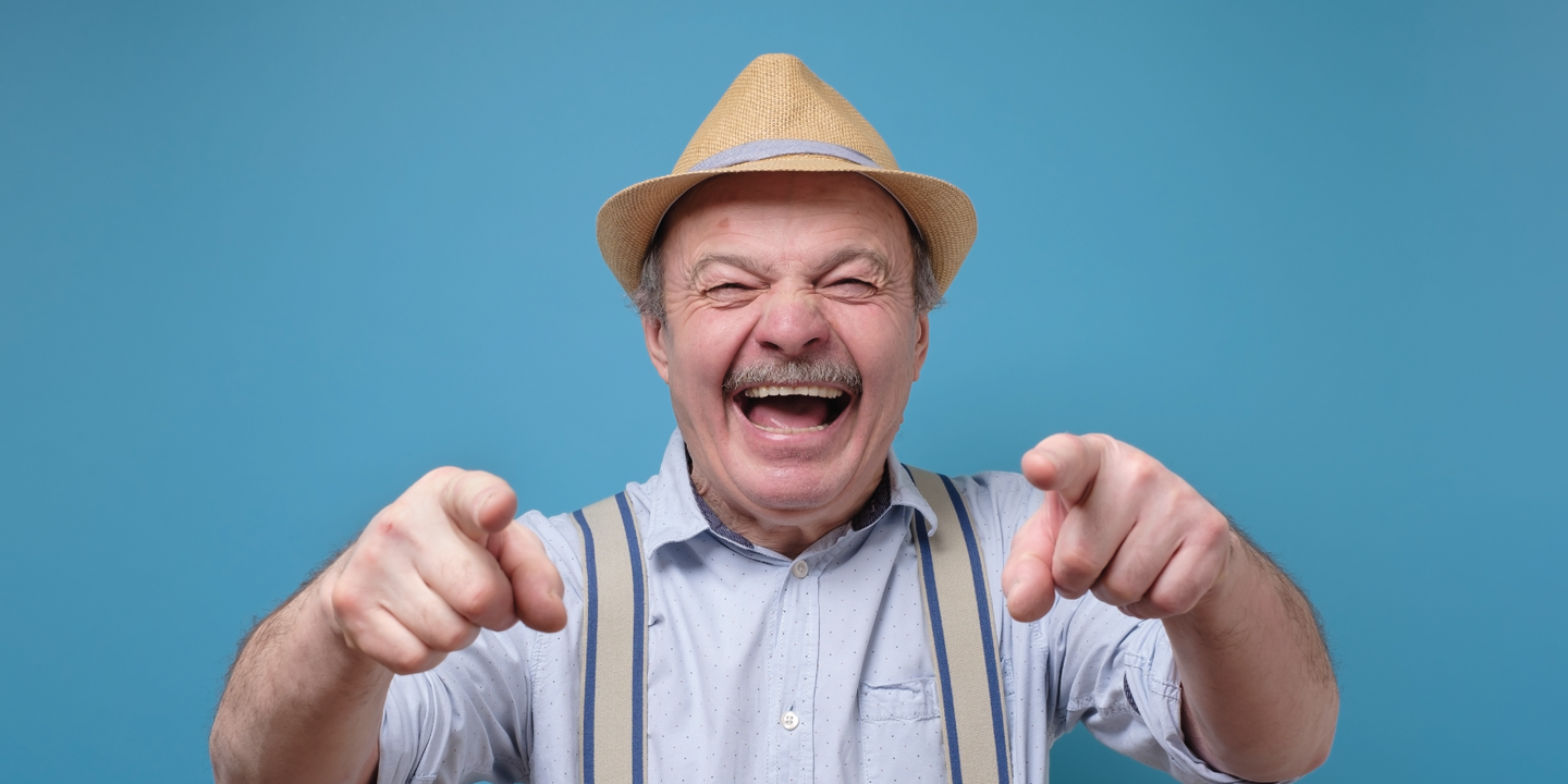 Older man pointing and laughing