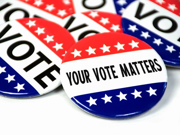 Collection of election campaign vote pins on white