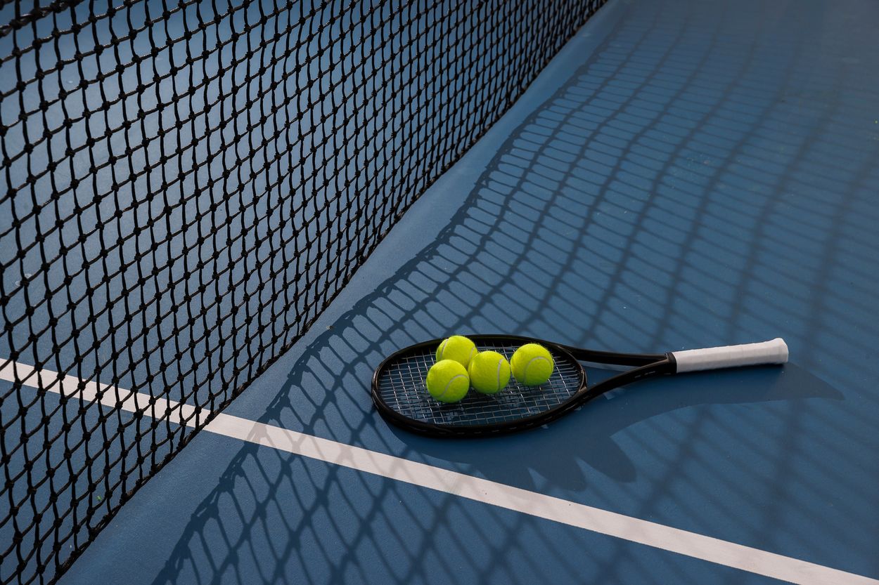 Tennis racket on floor of tennis court