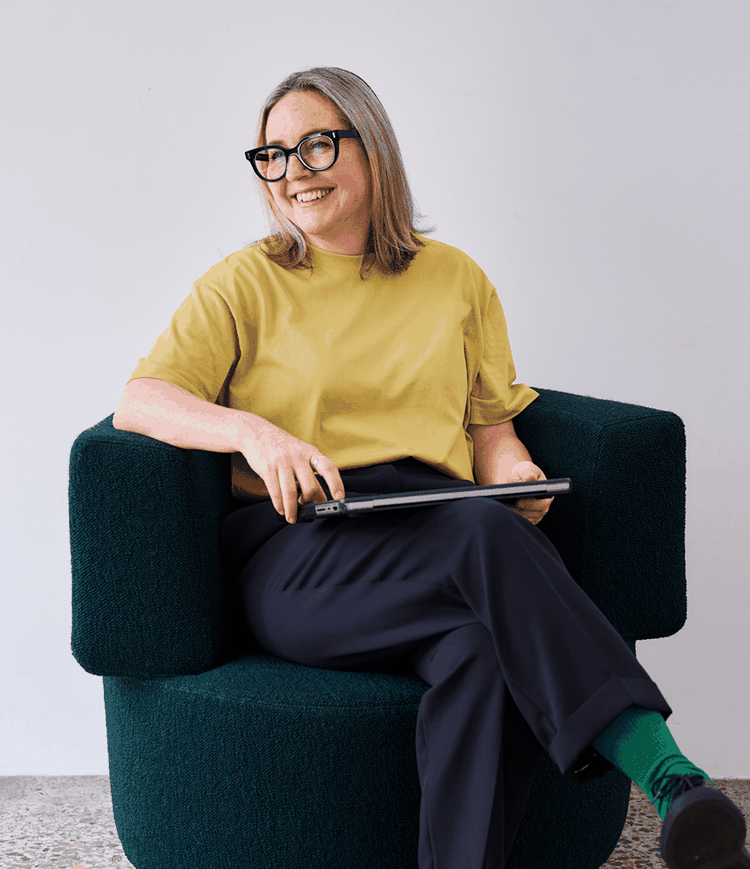 Woman with glasses sitting and smiling