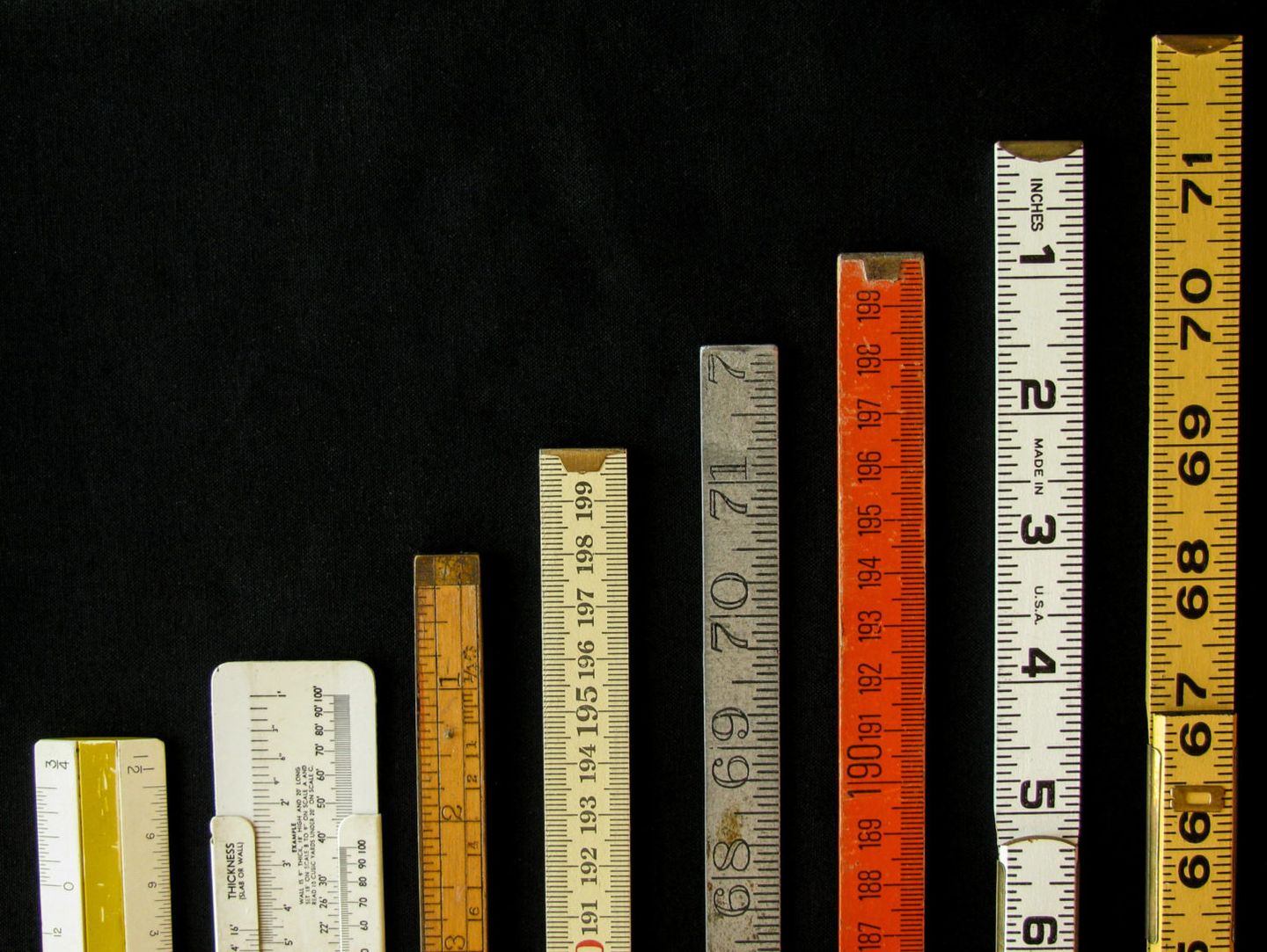 Rulers and scales in metric and inches ascend along a chart or graph representing measurement metrics precision increase growth accuracy and results with copy space