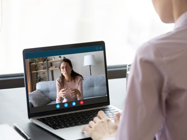 Businesswoman having distant negotiations using video conference application on pc
