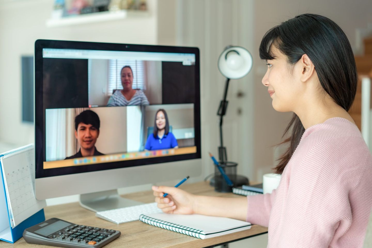 Asian business woman talking to her colleagues about plan in video conference multiethnic business team using computer for a online meeting in video call group of people smart working from home