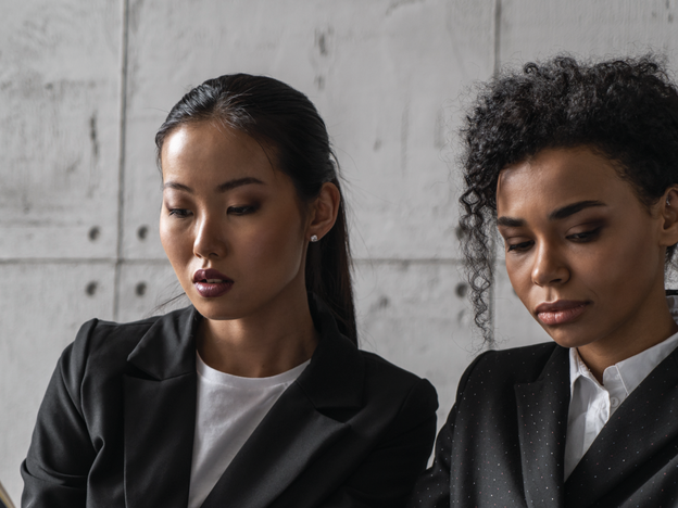 Image of two feminine-presenting individuals talking to each other
