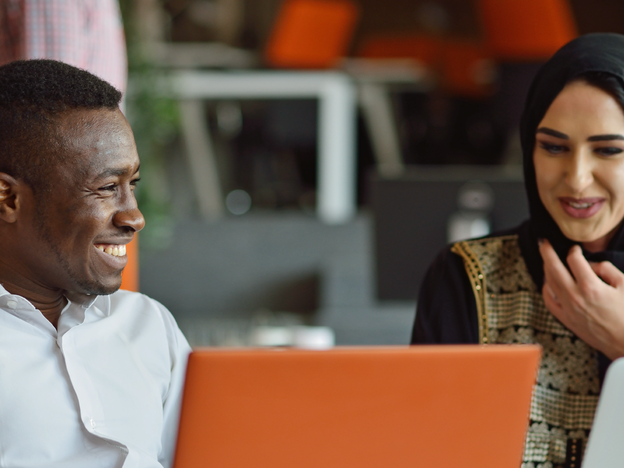 Two people talking with laptops