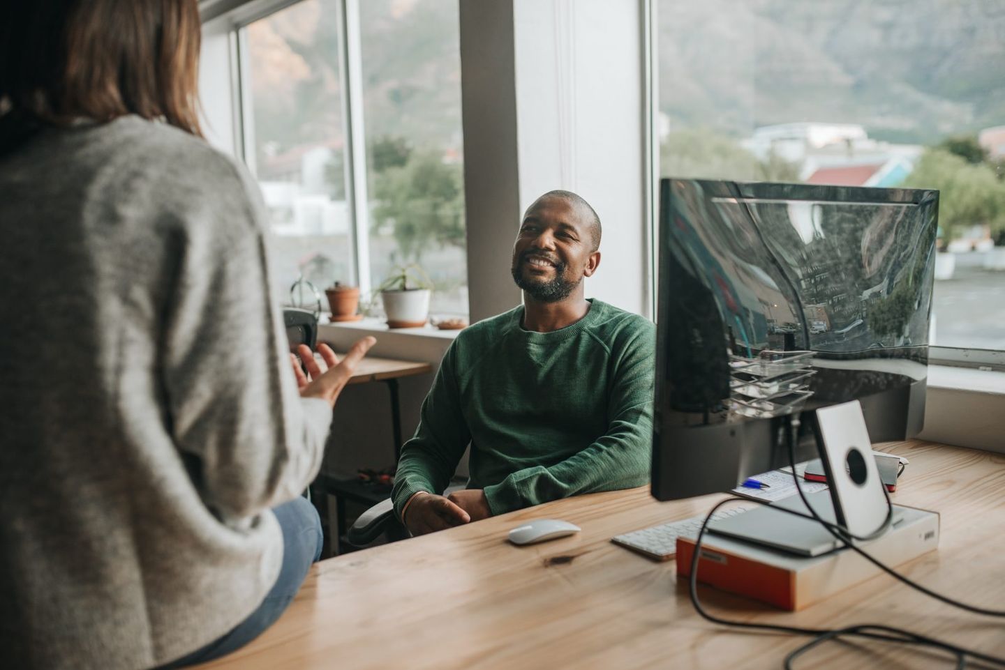 Smiling african american designer talking with a colleague at work