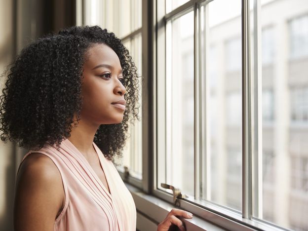 Young black businesswoman looking out of window