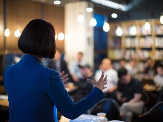 Woman presenting to audience business presentation conference meeting