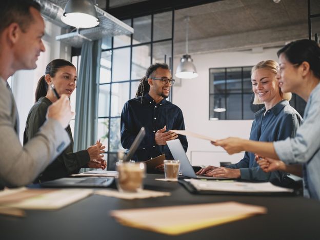 employees standing around board room table