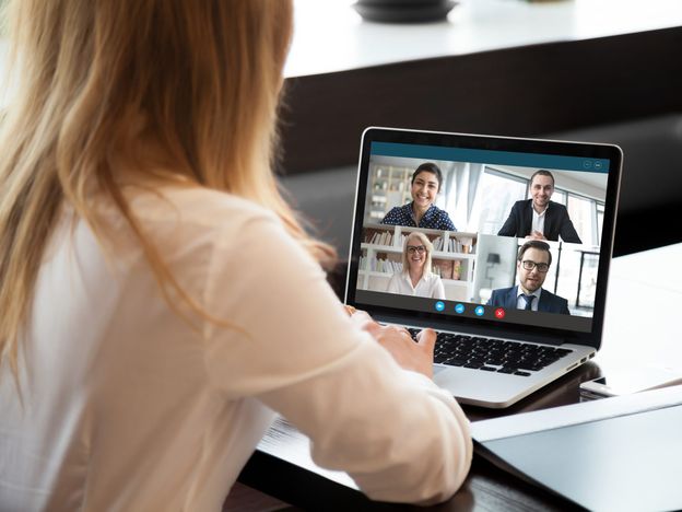 Female employee have team web conference on laptop