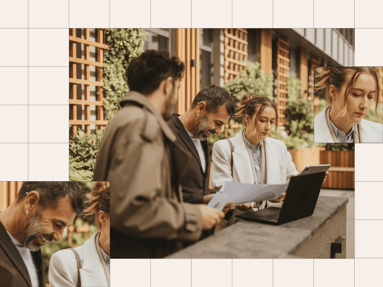 three coworkers outside working on laptops