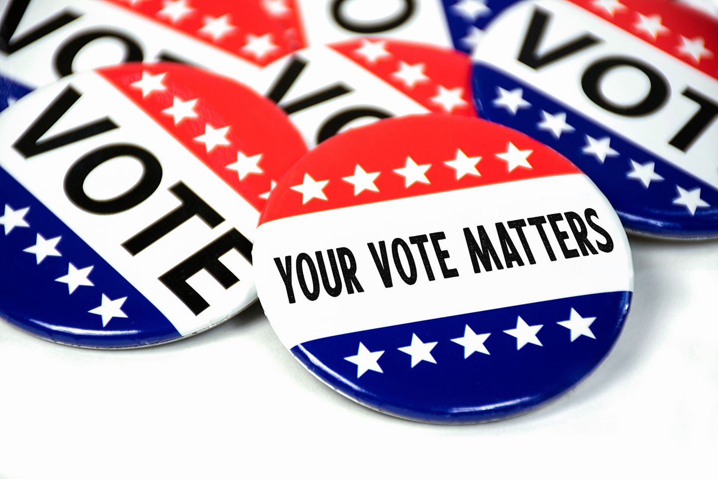 Collection of election campaign vote pins on white