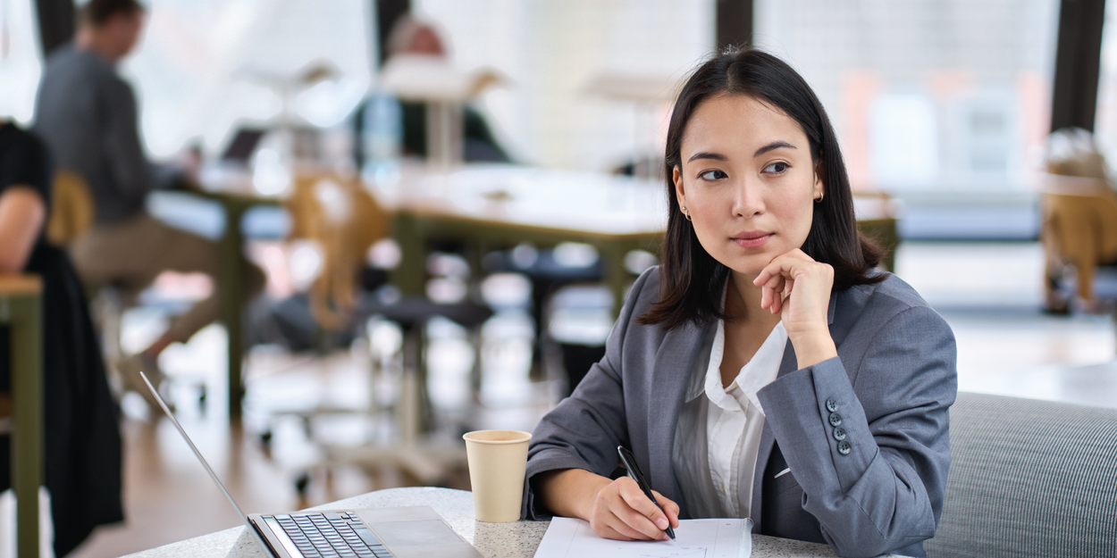 Thoughtful employee looking away from laptop