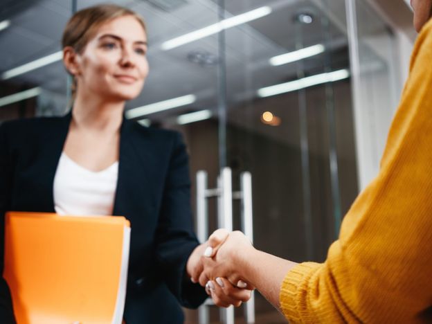 Handsome businesswomen handshaking after succsessful deal positive working moment business people partnership handshake meeting concept focus on hands