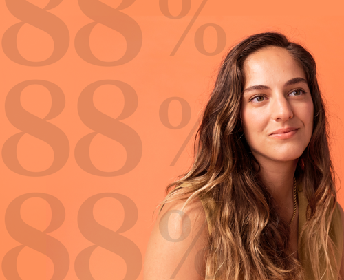 woman smiling in front of orange background