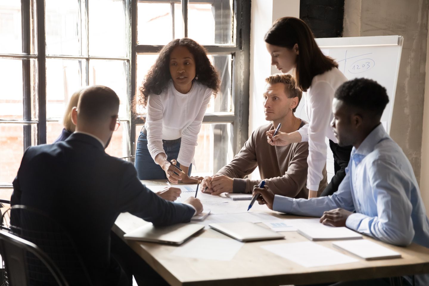 Serious diverse business team and african leader discuss financial paperwork