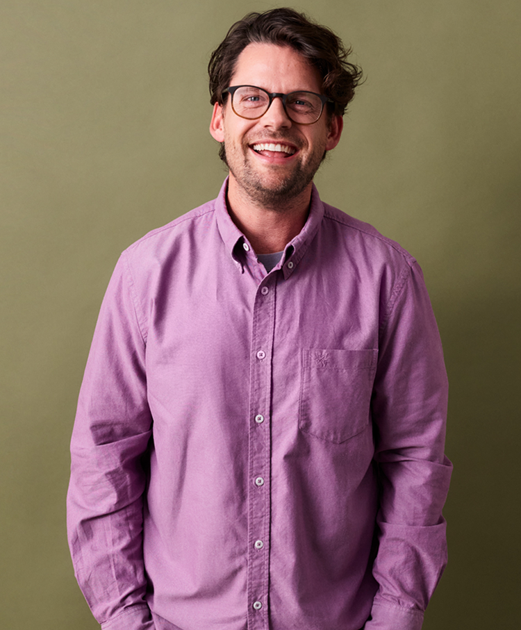 Man smiling in purple button up shirt